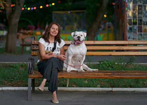 woman sitting on a park bench with her dog