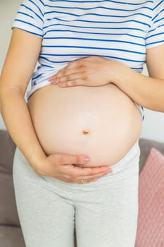 Pregnant woman hugs her belly. Selective focus. Cute.