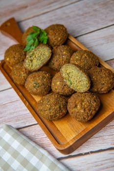 Falafel balls on a wooden cutting board and tahini sauce, High quality photo
