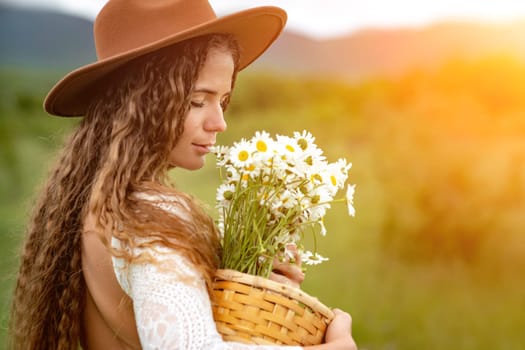 A middle-aged woman in a white dress and brown hat holds a large bouquet of daisies in her hands. Wildflowers for congratulations.