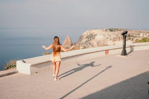 silhouette of a happy woman who dances, spins and raises her hands to the sky. A woman is enjoying a beautiful summer day.