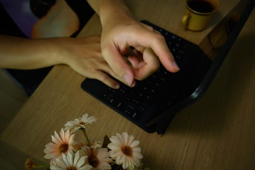 Close up view of male worker hand pointing on screen of digital tablet, working at wooden desk.