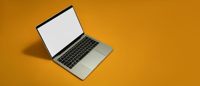 Mock up laptop with white empty screen on yellow background with copy space for your advertise text.