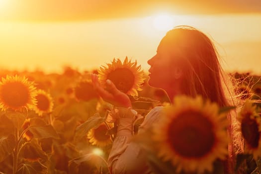 Woman in the sunflowers field. Summer time. Young beautiful woman standing in sunflower field.