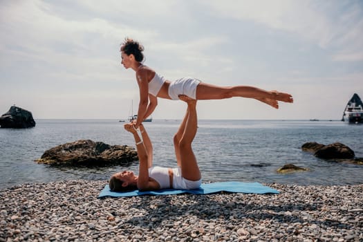 Woman sea yoga. Back view of free calm happy satisfied woman with long hair standing on top rock with yoga position against of sky by the sea. Healthy lifestyle outdoors in nature, fitness concept.