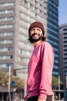 stylish young man smiling happy walking in the morning at city, concept of street style and urban lifestyle, copy space for text