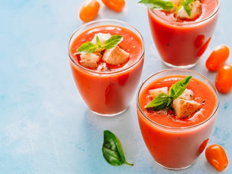 Delicious gaspacho soup in glass. Traditional spanish cold soup puree gaspacho or gazpacho on gray cement background with copy space for text. View from above or top view or flat lay