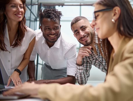 Diverse multinational team having a conversation in a conference room in a creative office.