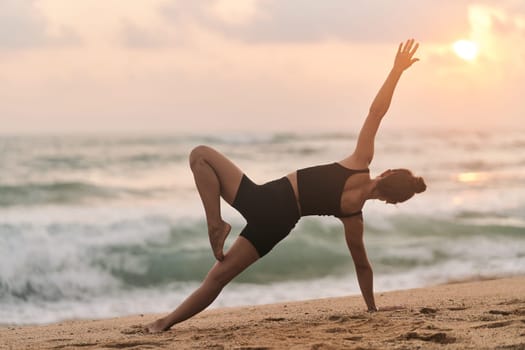 Beautiful girl doing yoga at the beach. High quality photo