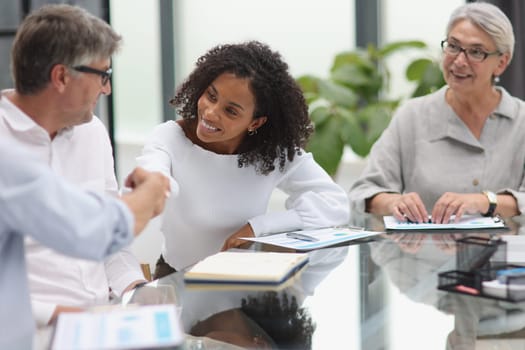 Cheerful businesswoman shaking hands with colleague