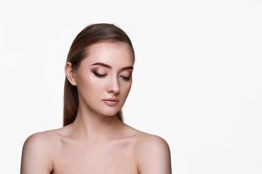 beautiful young woman with closed eyes and perfect skin on white background. copy space