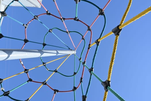 climbing net in children's playground , red rope Childrens playground in the city park. , . High quality photo.