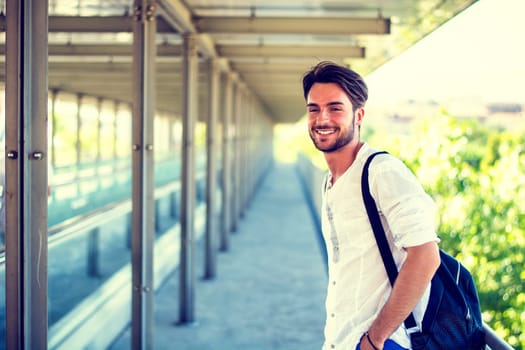 Handsome fit man in white shirt outdoor in city setting, looking away