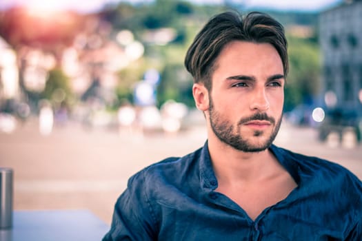 One handsome young man in urban setting in European city, Turin in Italy by the river Po