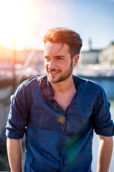 One handsome young man in urban setting in European city, Turin in Italy by the river Po