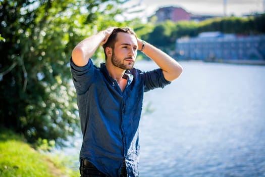 One handsome young man in urban setting in European city, Turin in Italy by the river Po