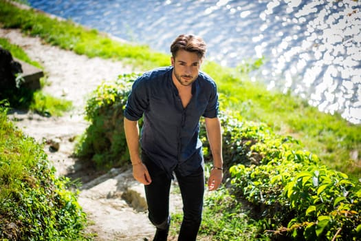 One handsome young man in urban setting in European city, Turin in Italy by the river Po