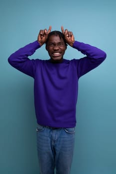 positive african american young man with dreadlocks in a blue sweatshirt.