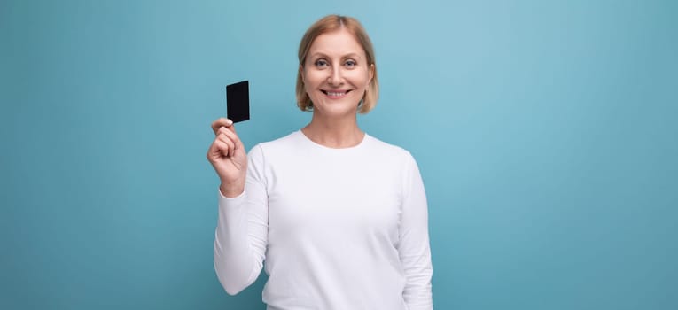 panoramic photo of blonde middle aged woman in white sweater with money card mockup.
