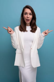 portrait of surprised shocked brunette woman in white dress with nice features.