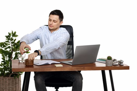 businessman in blue shirt taking notes, using laptop computer on white background