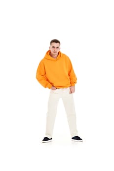 young handsome man in orange blank sweatshirt with space for your logo or design on white background. Mockup for print Full length