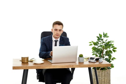 young man using laptop computer for online work at table on white background