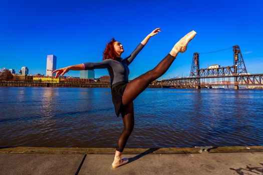 Young female ballet dancer practices at waterfront, Portland downtown.