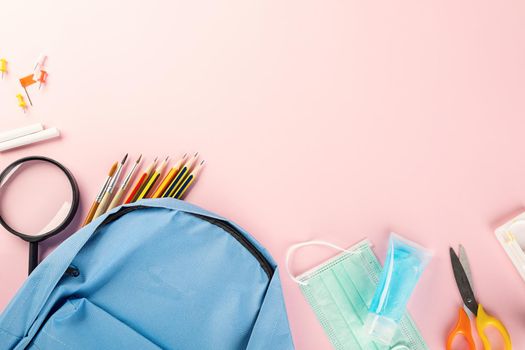 Back to school or college concept. Top view of school supplies stationery, backpack and surgical face mask, isolated on pink background, Back to start education new normal during outbreak coronavirus