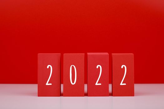 2022 Happy New Year red minimal trendy concept. Modern composition with red blocks with written 2022 numbers against red background with copy space. 