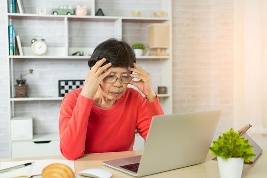 Senior woman depression and serious about checking Bitcoin price chart on digital exchange on laptop