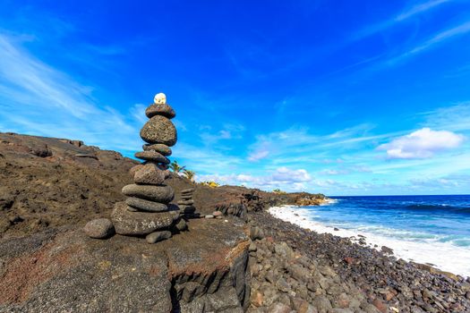Black stone Cairn (ahu) at Kaimu beach park, Big Island, Hawaii.