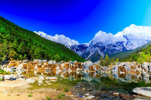 A view of a river and Jade Dragon Snow Mountain in Lijiang (Southwest China).