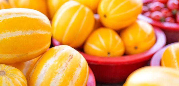 Delicious korean stripe yellow melon fruit food in red plastic basket at tradition market afternoon, Seoul, South Korea, harvest concept, close up.