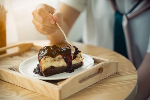 Women eating blueberry cheesecake on the wood table in the cafe