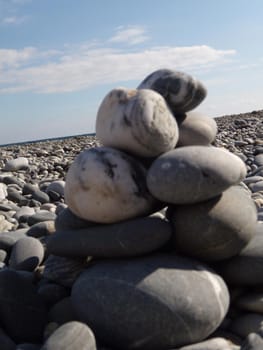 Zen stones on the beach. Abstract sea pebbles tower closeup. Concept of Stones balance and harmony pebbles stack on the beach during daytime on a sunny day