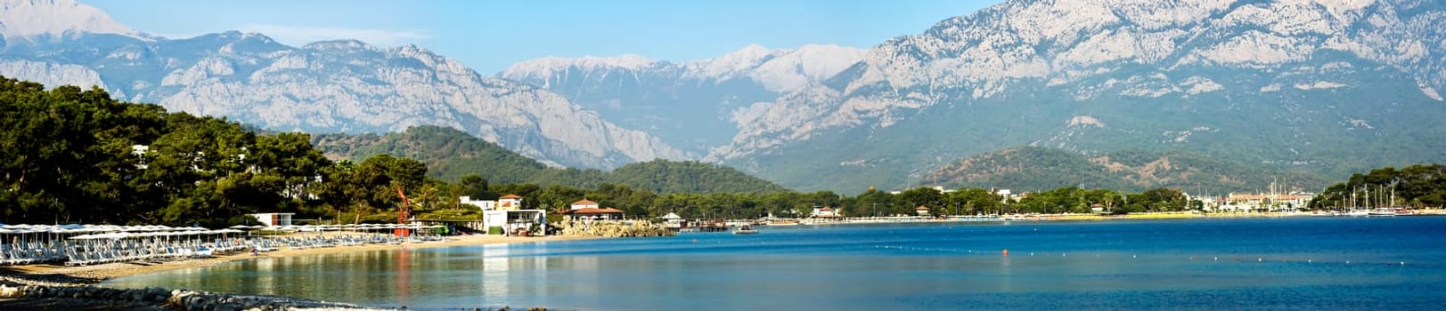 Kemer Antalia nice view of the sea. Beach Kemer Antalia with sand and mountains, the sea with the ship. Beautiful harbor near the sandy beach.