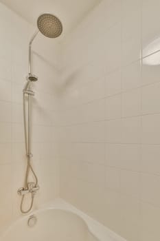 a bathtub with the shower head in it's position and hands on the edge of the tubpipe