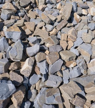 Gravel texture. Pebble stone background. Light grey closeup small rocks. Top view of ground gravel road.