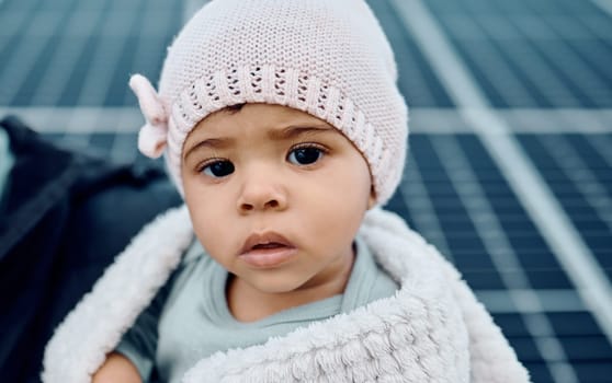 Portrait, baby and beanie with a girl child in a blanket during winter looking cute or adorable. Children, babies and face with a small female kid feeling curious or serious while keeping warm.