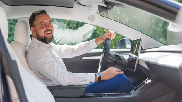 Caucasian bearded man in a suit driving a car