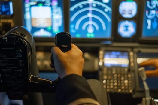 A man is studying to be a pilot in a flight simulator. Close-up of male hands navigating an aircraft