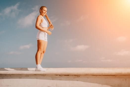 Fitness woman sea. Outdoor workout on yoga mat in park near to ocean beach. Female fitness pilates yoga routine concept. Healthy lifestyle. Happy fit woman exercising with rubber band in park.