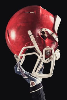 Soccer player on a dark background in vintage style. The classic American game. college Students. close-up helmet