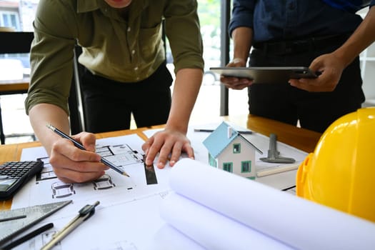 Architects team collaborating, planning working together at co working space in office.