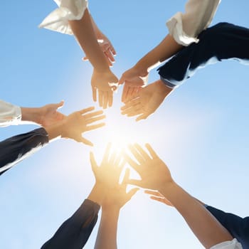 Below hands circle, business people or teamwork by sky background for support, solidarity or goal. Men, women and group with helping hand in air for collaboration, motivation or outdoor team building.