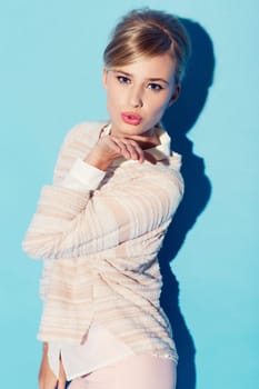 Portrait, valentines day and blow on kiss with a woman in studio on a blue background for love or flirting. Fashion, kissing and hand gesture with an attractive young female model posing for romance.