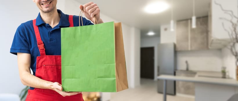 box with fast food being carried by delivery man in uniform for one of clients.