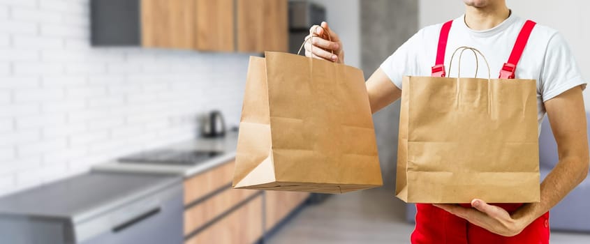 Young handsome man holding delivery paper bag.