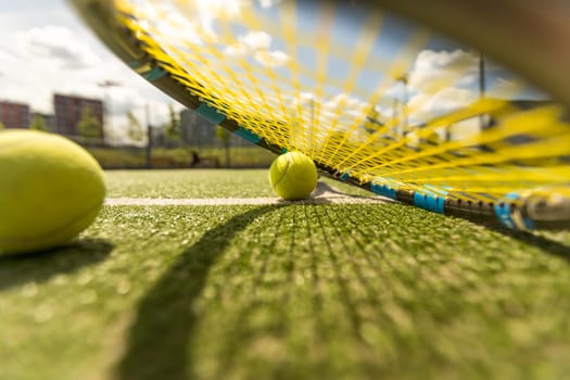 tennis racket with a tennis ball on a tennis court.